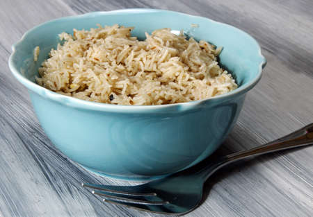 Spicy zeera aromatic Basmati rice in a bowl on wooden background.の写真素材