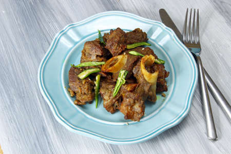 Mutton fry on a plate on grey background.の写真素材