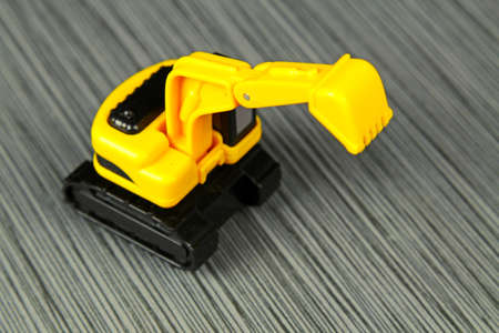 A yellow toy truck on a grey stone background with copy space, selective focusの写真素材