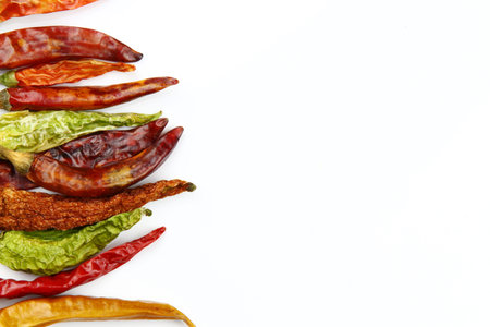 Red and green dried chili peppers on white background with copy spaceの写真素材