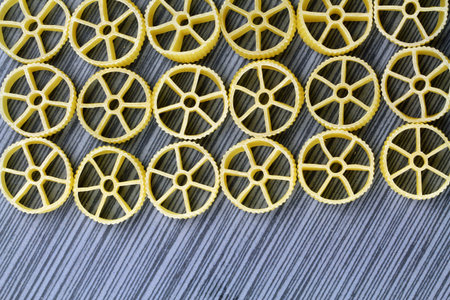 Wagon wheel pasta on a grey background with copy space, selective focus.