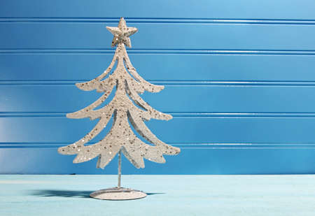 A decorative Christmas tree on a wooden blue background with copy spaceの写真素材