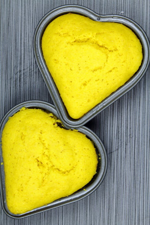 Top view of heart shaped corn bread cake on grey background