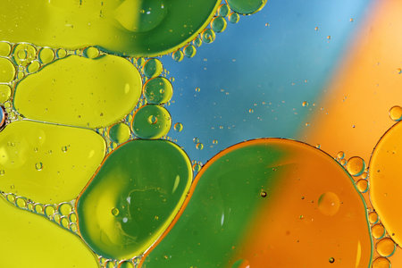 Oil in water forming green and orange circles abstract backgroundの写真素材