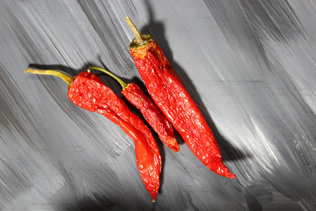 Shrvelled red chili pepper on a grey background
