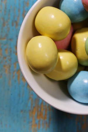 Top view of Easter candy on blue background with copy space, selective focus