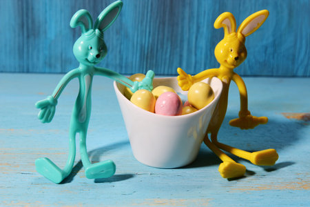 A bowl of Easter egg candy with two bunnies on a blue background