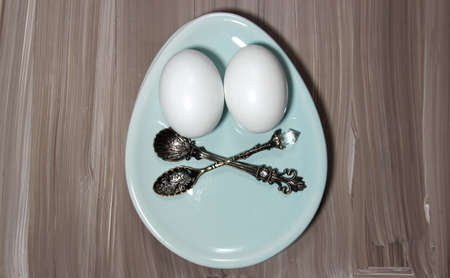 Top iew of eggs on a plate with spoons on a wooden backgroundの写真素材