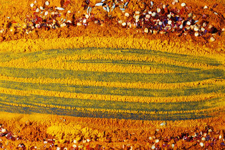 A background of turmeric powder and other spices with copy spaceの写真素材