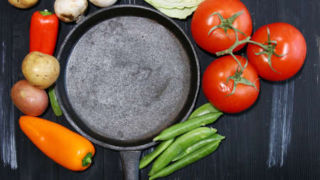 Top view of fresh Vegetables with a cast iron skillet in the center for text. Tomatoes, Potatoes, Peppers, Peas, Mushrooms.の写真素材