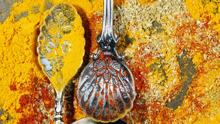 Yellow Turmeric  Red paprika  and coriander powder with empty spoons on rustic background, selective focus.の写真素材