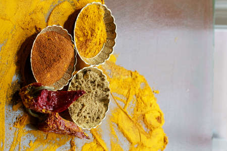 Close up of Indian spices of Turmeric powder, coriander powder and chili powder in  metal bowls.の写真素材