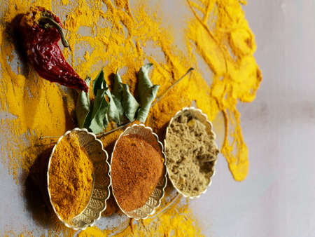 Close up of Indian spices of Turmeric powder, coriander powder and chili powder in  metal bowls.の写真素材