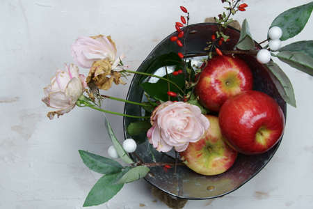 Overhead view of red apples in a tin with rose flowers.の写真素材