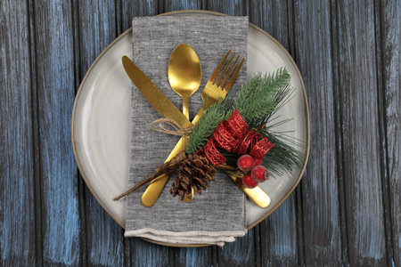 Overhead view of  table setting - a plate with spoon, fork and knife with a Christmas decoration on...
