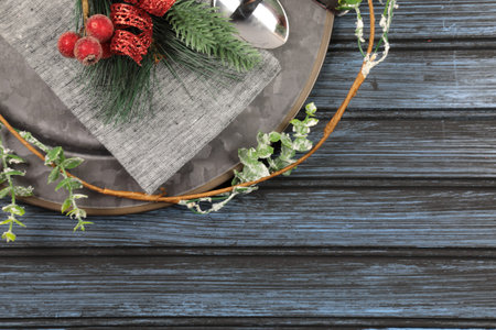 Overhead view of  table setting - a plate with spoon, fork and knife with a Christmas decoration on a wooden background.の写真素材