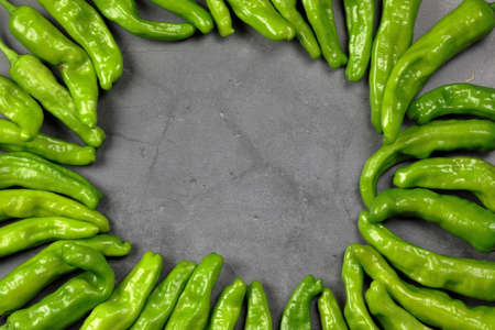 Green Shishito peppers in a circle with an empty space in the center for copy space.の写真素材