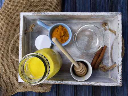 Turmeric latte, golden milk or the Indian Haldi Doodh with superfood Turmeric powder, Ginder and...