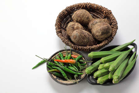 Indian vegetables of Yams or Taro root , Lady's finger or Okra and green chilies wooden background with copy space.の写真素材