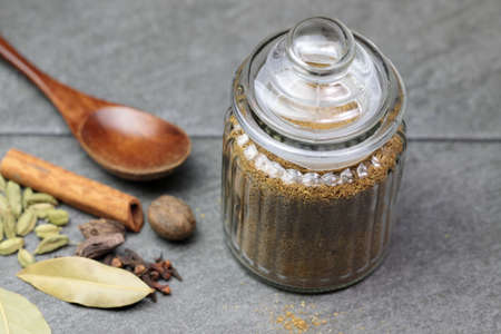 A jar with a spicy and aromatic Indian Garam Masala powder on grey background.の写真素材