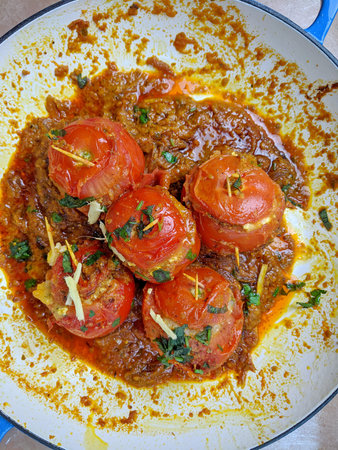 A pan of Paneer and Potato stuffed Tomato Masala