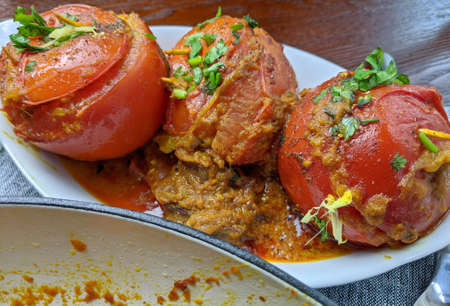 A platter of Paneer and Potato stuffed Tomato Masalaの写真素材