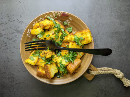 A bowl of homemade freshly prepared Bread Upma, a savory and spicy South Indian bread dish on grey...