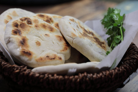A close up of a basket of Baati roti for breakfast.
