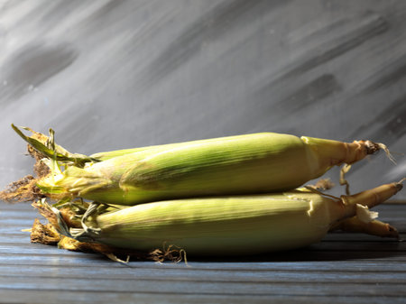 Uncooked Sweet corn on a wooden background