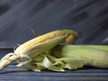Uncooked Sweet corn on a wooden background