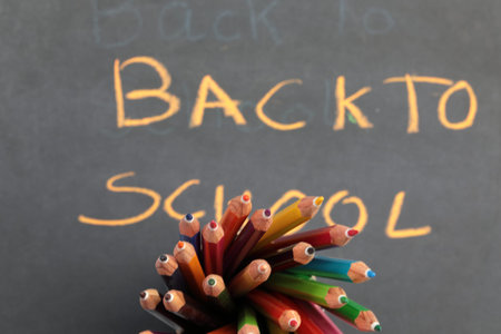 A bunch of Colourful pencils with defocused text in the background. Back to school concept.