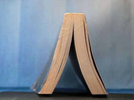 An inverted reading book on blue background.の写真素材