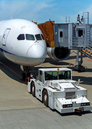 Modern Airplane at jetway ready for pushback at airport