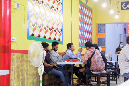 Grill 99 Barong Tongkok Kutai Barat, Indonesia - January 09, 2021: Cafe room with beautiful and modern decoration at night with lovely customersのeditorial素材