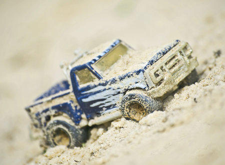 Closeup of toy offroad truck in sandの写真素材