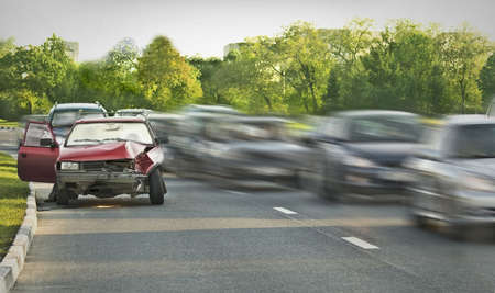 Crashed old car among traffic flowの写真素材