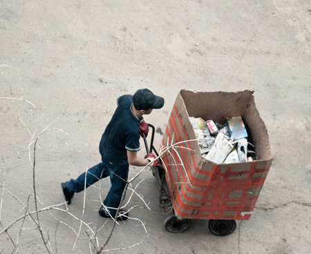 Russia, 2012. asian yard cleaner with his trash boxのeditorial素材