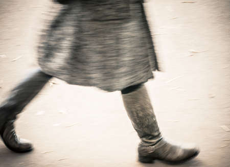 winter dressed woman, blurry walkingの写真素材