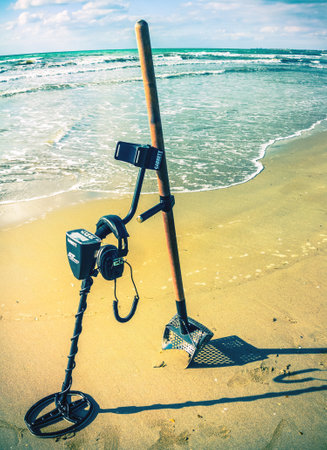 metal detector Garrett AT Pro and sand scoop ready to work on the beachのeditorial素材