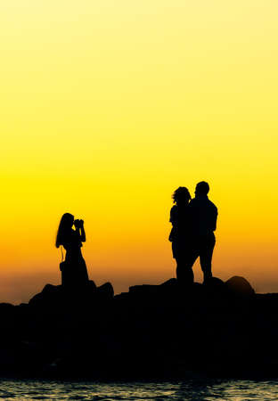 couple are photographing on sunset rocksの写真素材
