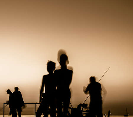 silhouette of fishermen at sunsetの写真素材
