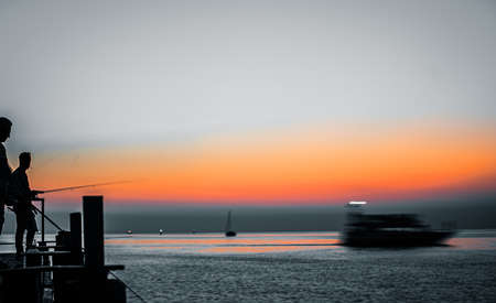 silhouette of fishermen at sunsetのイラスト素材