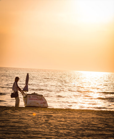 Anapa, Russia - september, 2020: ice-cream man has finished selling and is moving along evening beachのeditorial素材