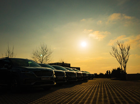 Moscow, Russia - March 28, 2021: Caravan of the new universal cars KIA Carnival are parked in sunset street (the license plates is changed)のeditorial素材