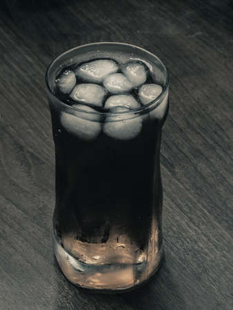 glass of icy drink in darkの写真素材