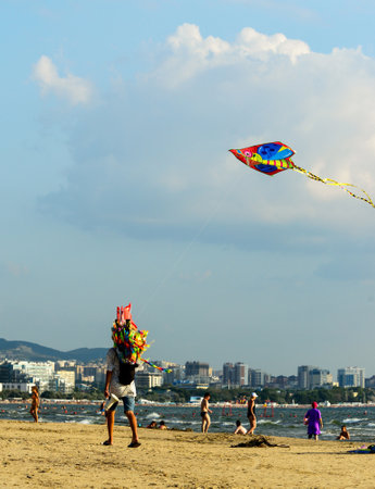 2021: man walks along beach and sells the colorful kitesのeditorial素材