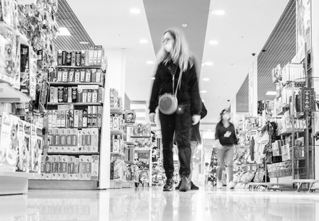 Moscow, Russia - October 02, 2021: female shoppers dressed medical masks walk through department store. black whiteのeditorial素材
