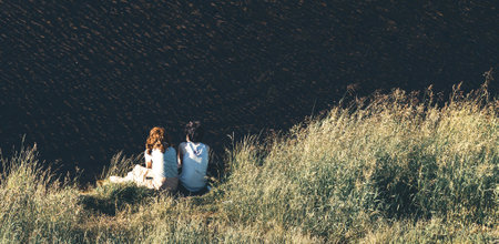two teen girls on river bankの写真素材