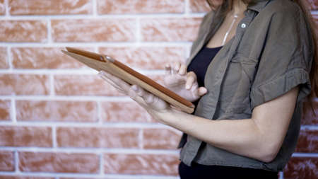 Side view of a young woman using digital tablet, close up shot. Social networking concept.の写真素材