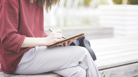 A closeup of tablet and female hand holding a green pencil writing on a touchscreen